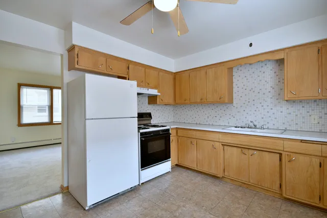 a kitchen with white cabinets and white appliances