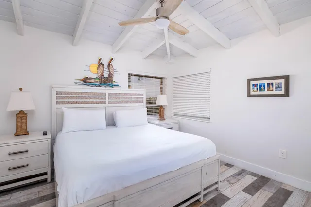 a bedroom with a bed and a flat tv screen on dresser