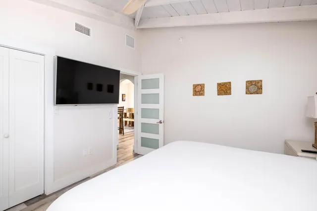 a bedroom with a bed and a flat screen tv