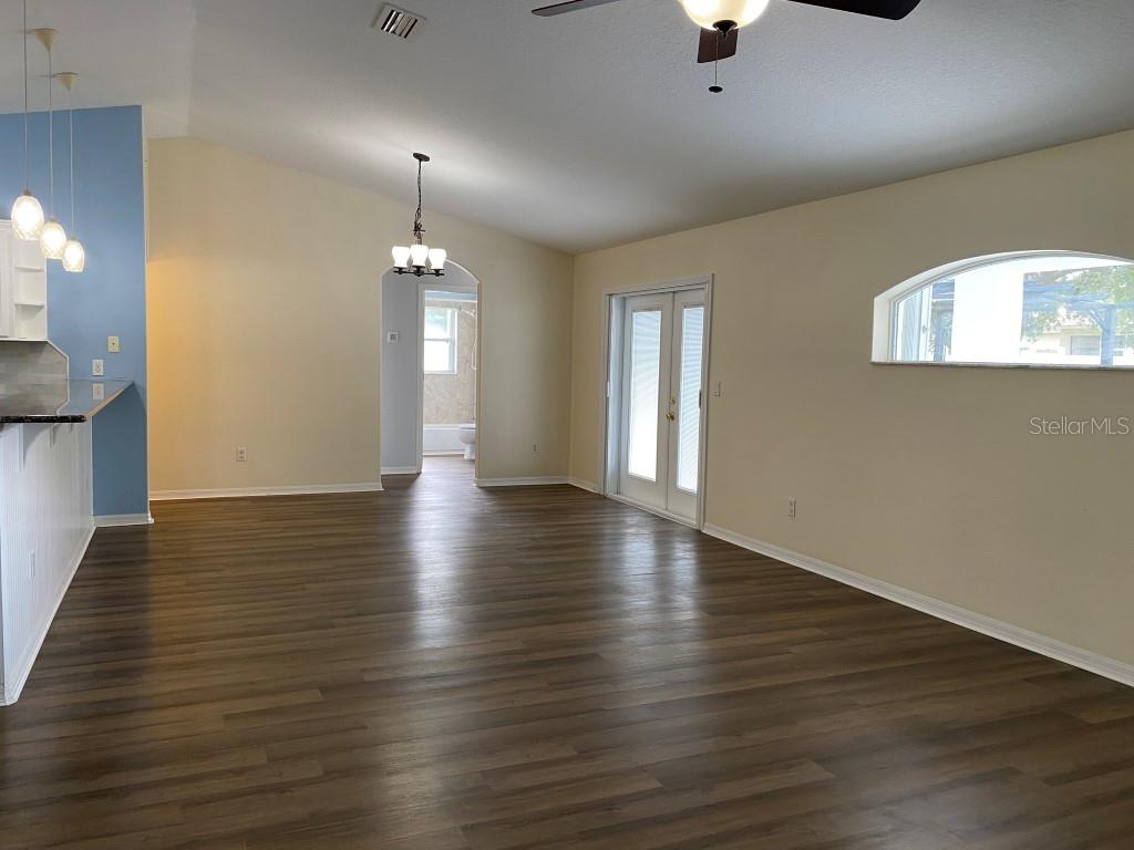 12 Prairie Lane Palm Coast, FL 32164 - Photo 5 of 41 an empty room with wooden floor chandelier and windows