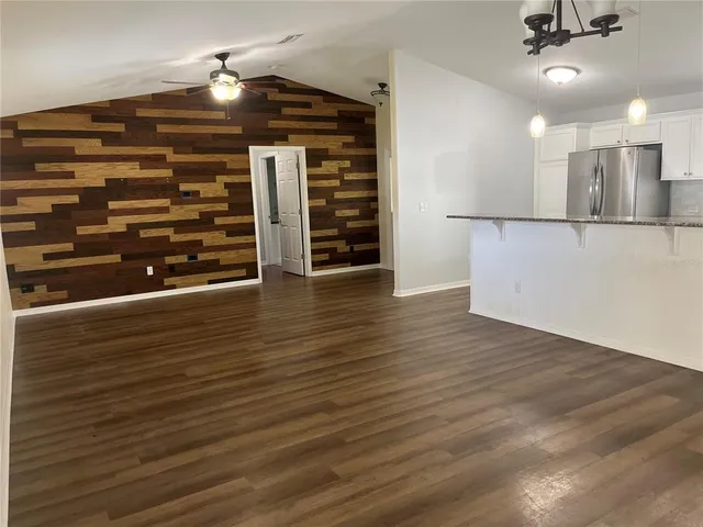 a kitchen with stainless steel appliances granite countertop a sink a stove top oven a wooden floors and white cabinets