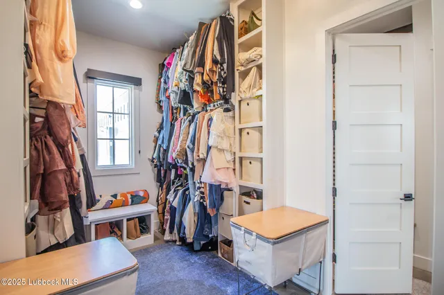 a living room with furniture kitchen view and large windows