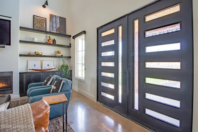 a living room with furniture a fireplace and a large window