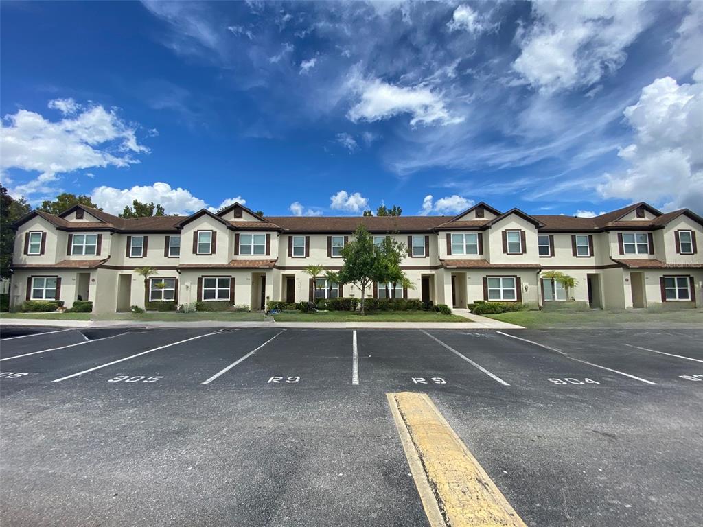 a view of big building with a big yard and large trees