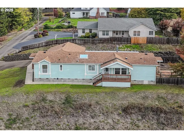 a aerial view of a house with a yard and large trees