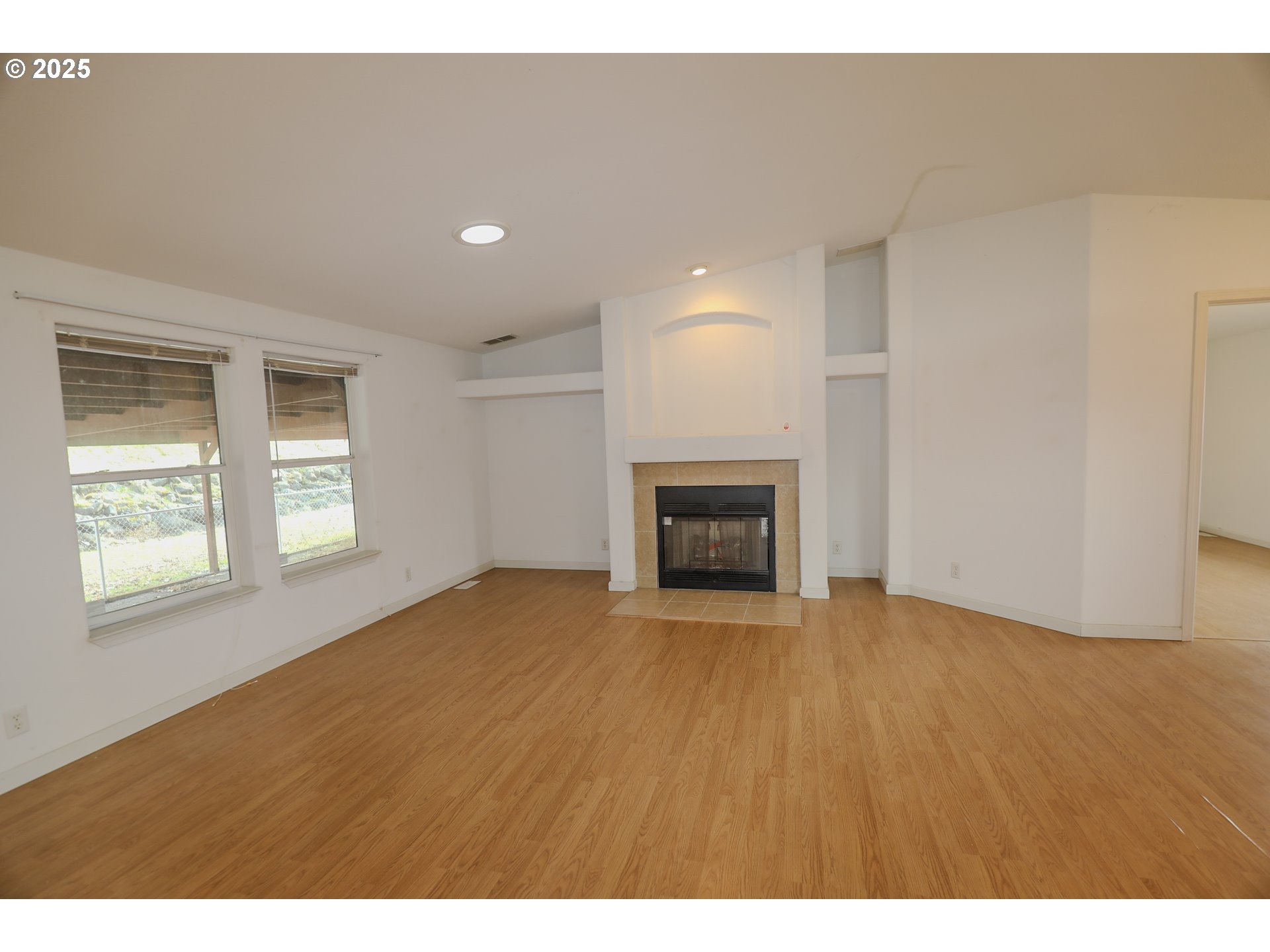 173 North Main Street Winston, OR 97496 - Photo 7 of 45 a view of an empty room with a fireplace and a window