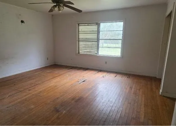 wooden floor in an empty room with a window