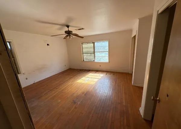 wooden floor in an empty room with a window