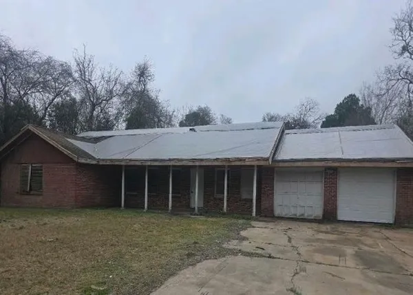 a front view of a house with a garden and tree