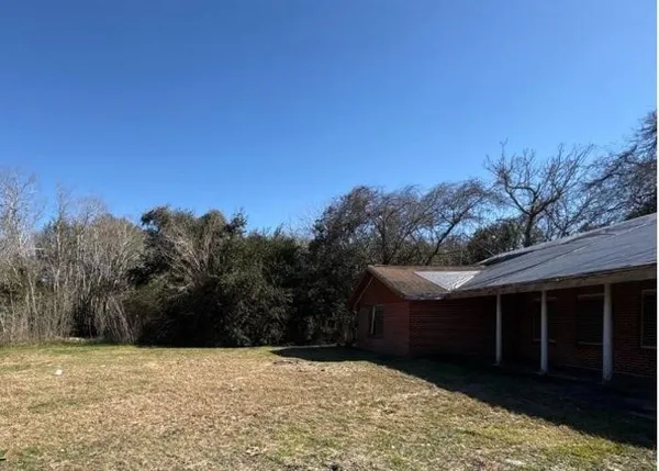 a view of wooden house with a yard