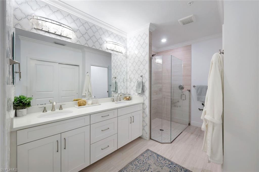 16348 Viansa Way, Unit 101 Naples, FL 34110 - Photo 14 of 34 a spacious bathroom with double sink a shower and a mirror