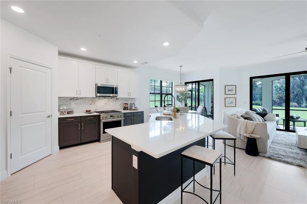 16348 Viansa Way, Unit 101 Naples, FL 34110 - Photo 7 of 34 a large kitchen with sink cabinets and stainless steel appliances