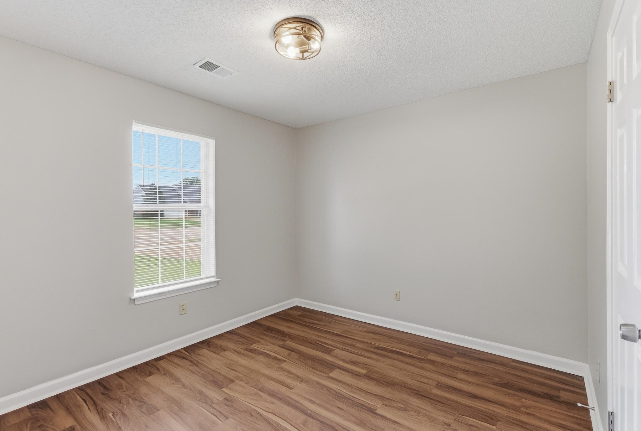 4101 Long Creek Road Memphis, TN 38125 - Photo 25 of 36 Wood-finish flooring with white baseboards and neutral wall paint