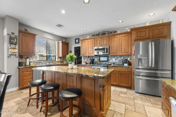 a kitchen with stainless steel appliances granite countertop a stove a sink and a microwave