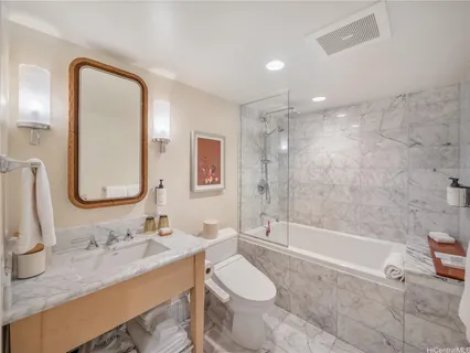 a bathroom with a granite countertop sink toilet and shower
