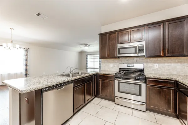 a kitchen with stainless steel appliances granite countertop a sink stove oven and granite counter tops