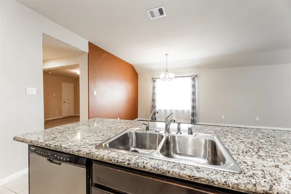 a kitchen with granite countertop a sink and a wooden floor