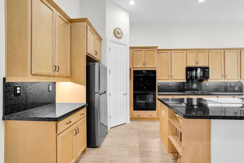 a kitchen with stainless steel appliances granite countertop a refrigerator and a sink