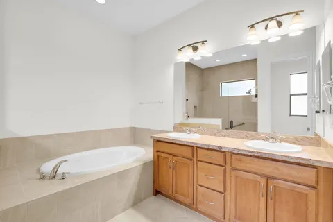 a bathroom with a granite countertop sink mirror and bathtub