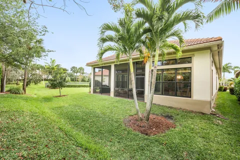 a view of a house with a yard and palm trees