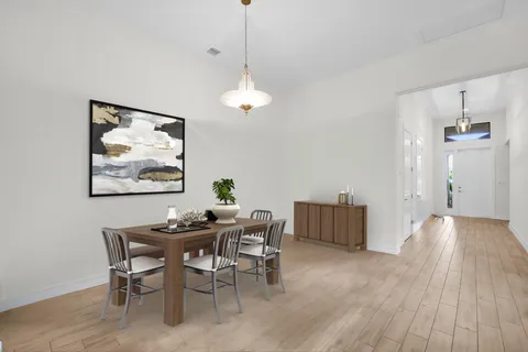 a dining room with furniture wooden floor a rug and a chandelier