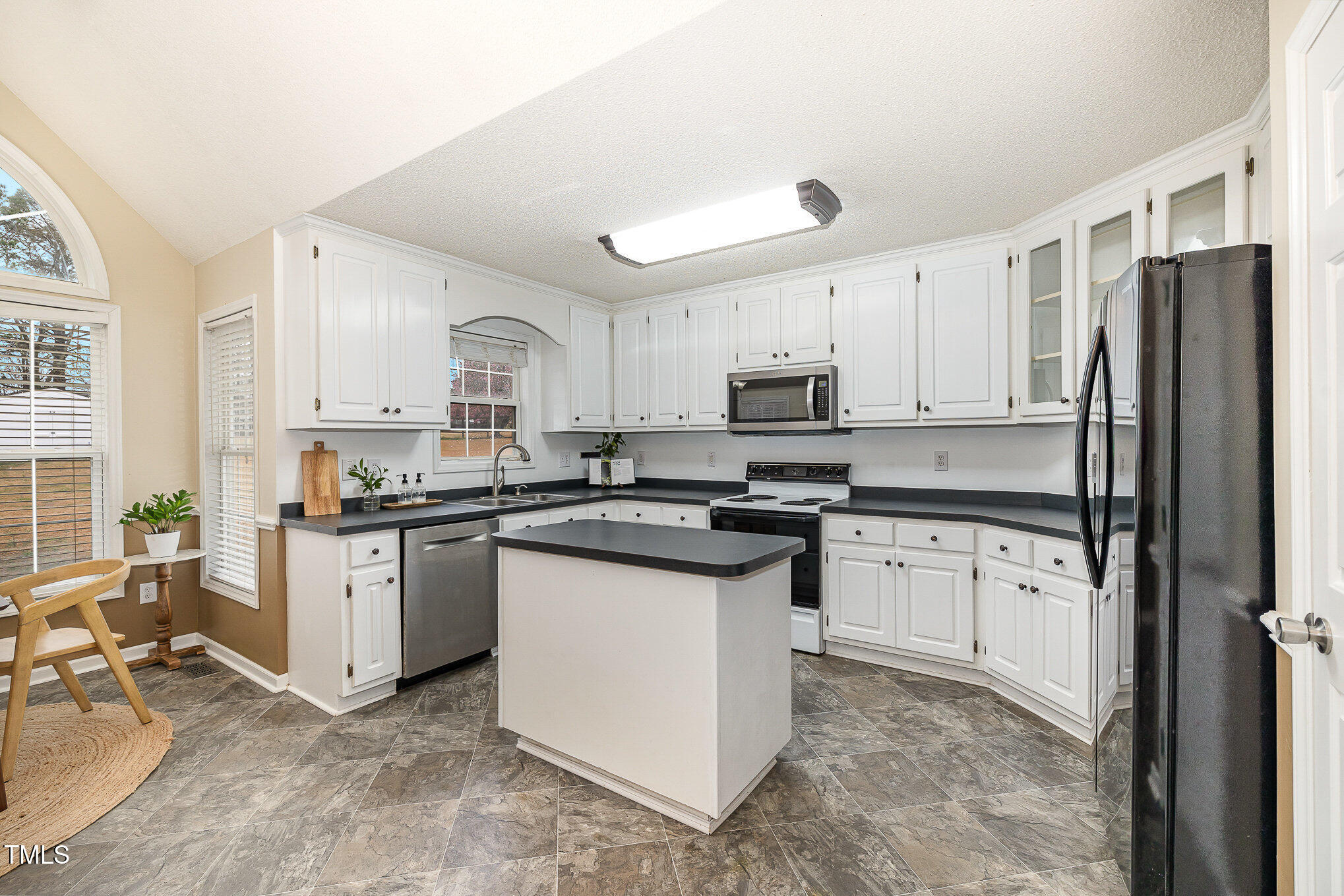 3733 Polenta Road Clayton, NC 27520 - Photo 7 of 51 a kitchen with granite countertop white cabinets and white appliances