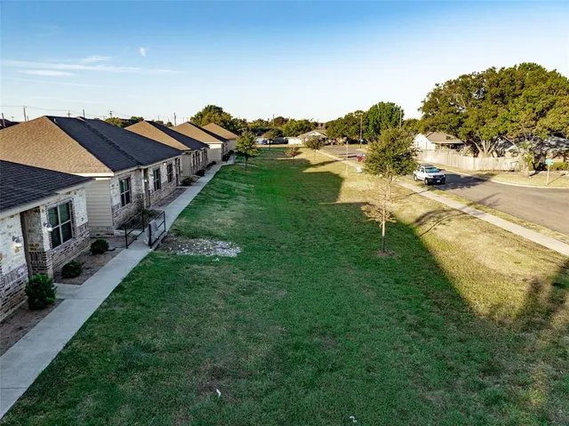 a aerial view of residential houses with outdoor space and trees