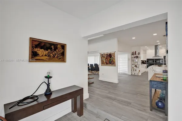 a living room with furniture and kitchen view with wooden floor