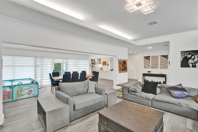 a living room with furniture large window and a table