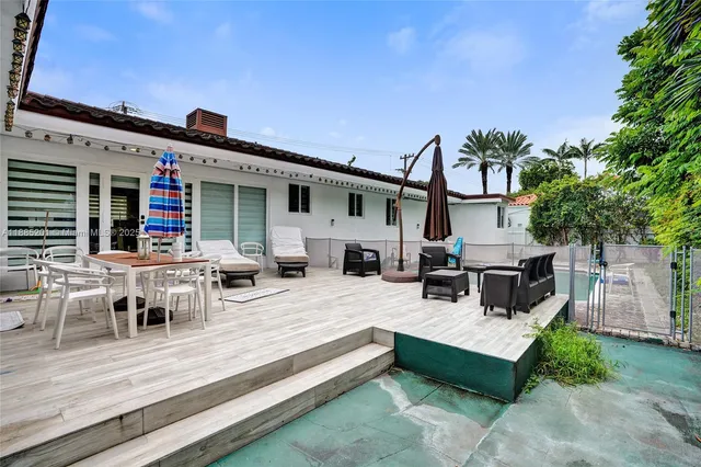 a backyard of a house with table and chairs