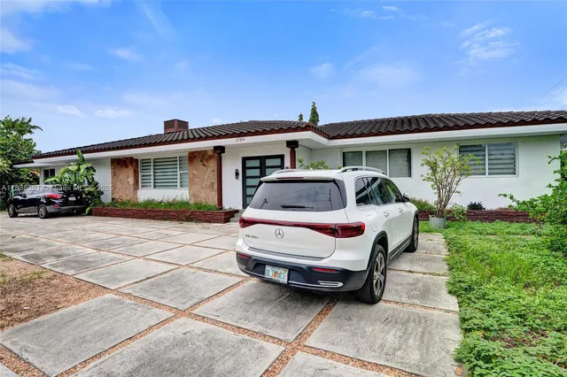 a front view of a house with a garden and plants