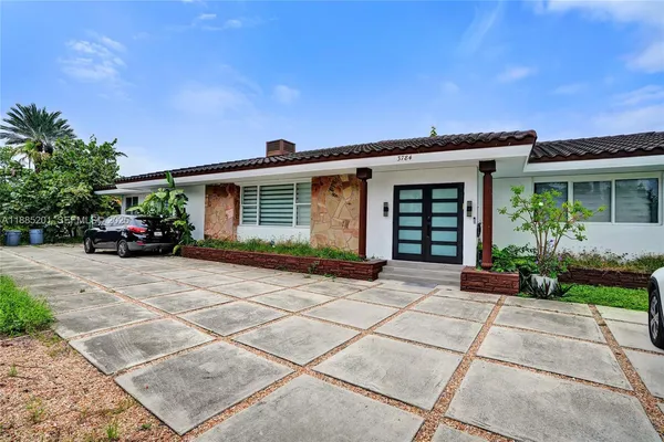 a kitchen with stainless steel appliances granite countertop a refrigerator a sink dishwasher a dining table and chairs with wooden floor