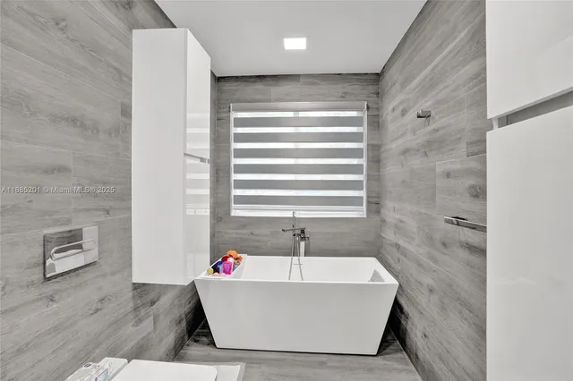 a room with a bed and a view of kitchen