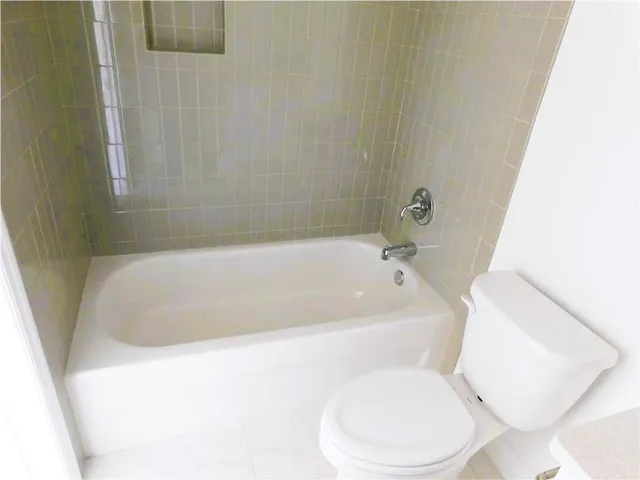 a white bath tub sitting next to a white toilet