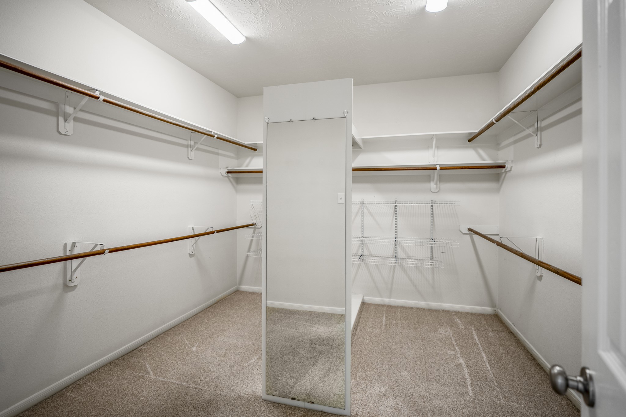 6218 Stone Trail Lane Spring, TX 77379 - Photo 19 of 50 The spacious walk-in closet completes the primary suite, offering built-in shelving and double hanging rods on both sides to keep everything organized and easy to access. The layout allows room to move comfortably while giving wardrobes, shoes, and accessories a dedicated place to land.