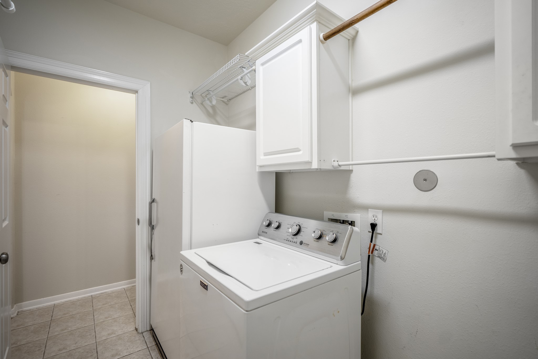 6218 Stone Trail Lane Spring, TX 77379 - Photo 26 of 50 Just beyond the secondary bedrooms, the utility room keeps everyday routines simple with space for full-size appliances, overhead cabinetry, and added shelving for supplies. Positioned off the main hallway, it’s an easy, practical stop that stays tucked away from the living areas.