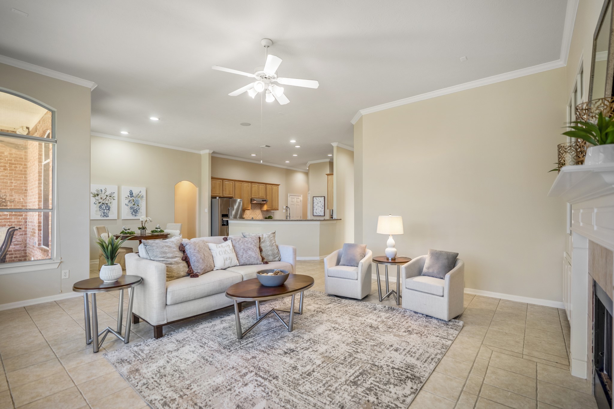 6218 Stone Trail Lane Spring, TX 77379 - Photo 9 of 50 An open view back toward the kitchen highlights how easily the living room connects to the surrounding spaces, making everyday routines and entertaining feel effortless. With tile flooring underfoot and generous seating areas throughout, the layout supports both relaxed evenings and lively gatherings without missing a beat.