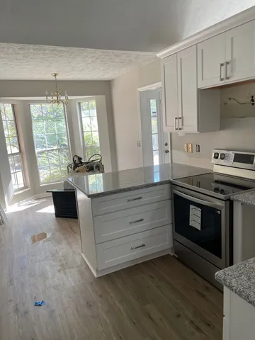 a kitchen with granite countertop a stove and a sink