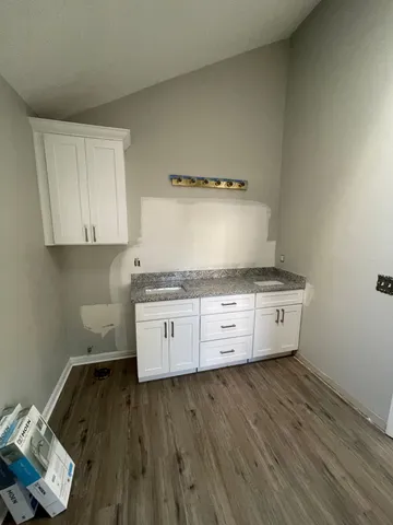 a kitchen with granite countertop a stove and a wooden floors