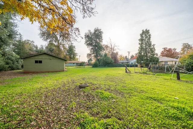 a view of a house with a yard and a tree