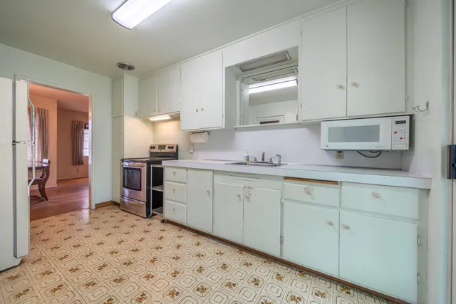 a kitchen with granite countertop white cabinets and sink