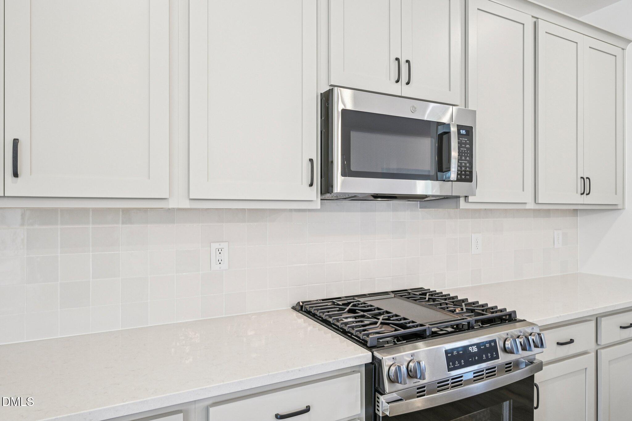 142 North Harvest Rdg Way, Unit HOMESITE 310 Clayton, NC 27520 - Photo 14 of 43 a kitchen with white cabinets and appliances