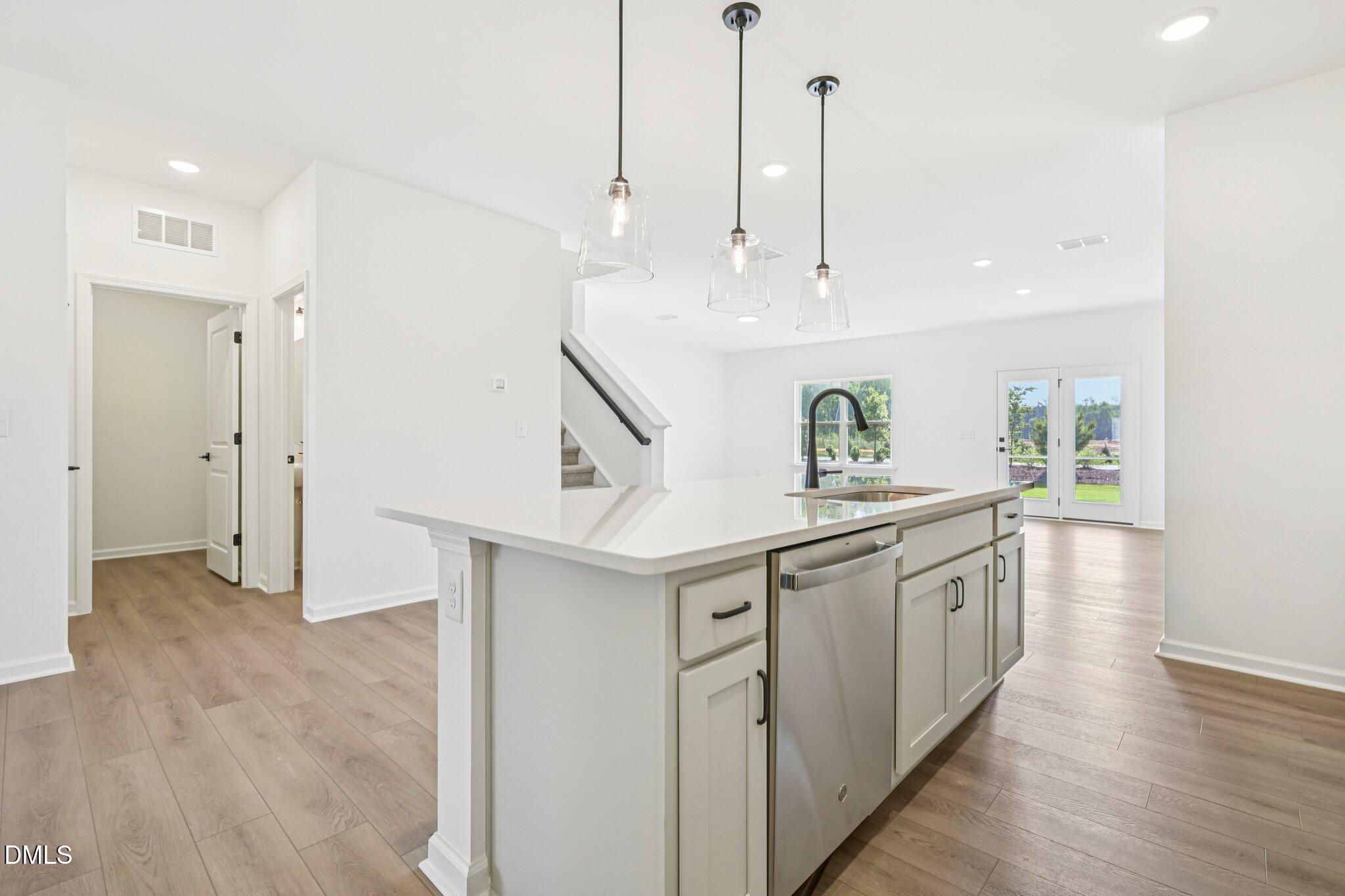 142 North Harvest Rdg Way, Unit HOMESITE 310 Clayton, NC 27520 - Photo 15 of 43 a kitchen with stainless steel appliances granite countertop a sink a stove a refrigerator and island with wooden floor