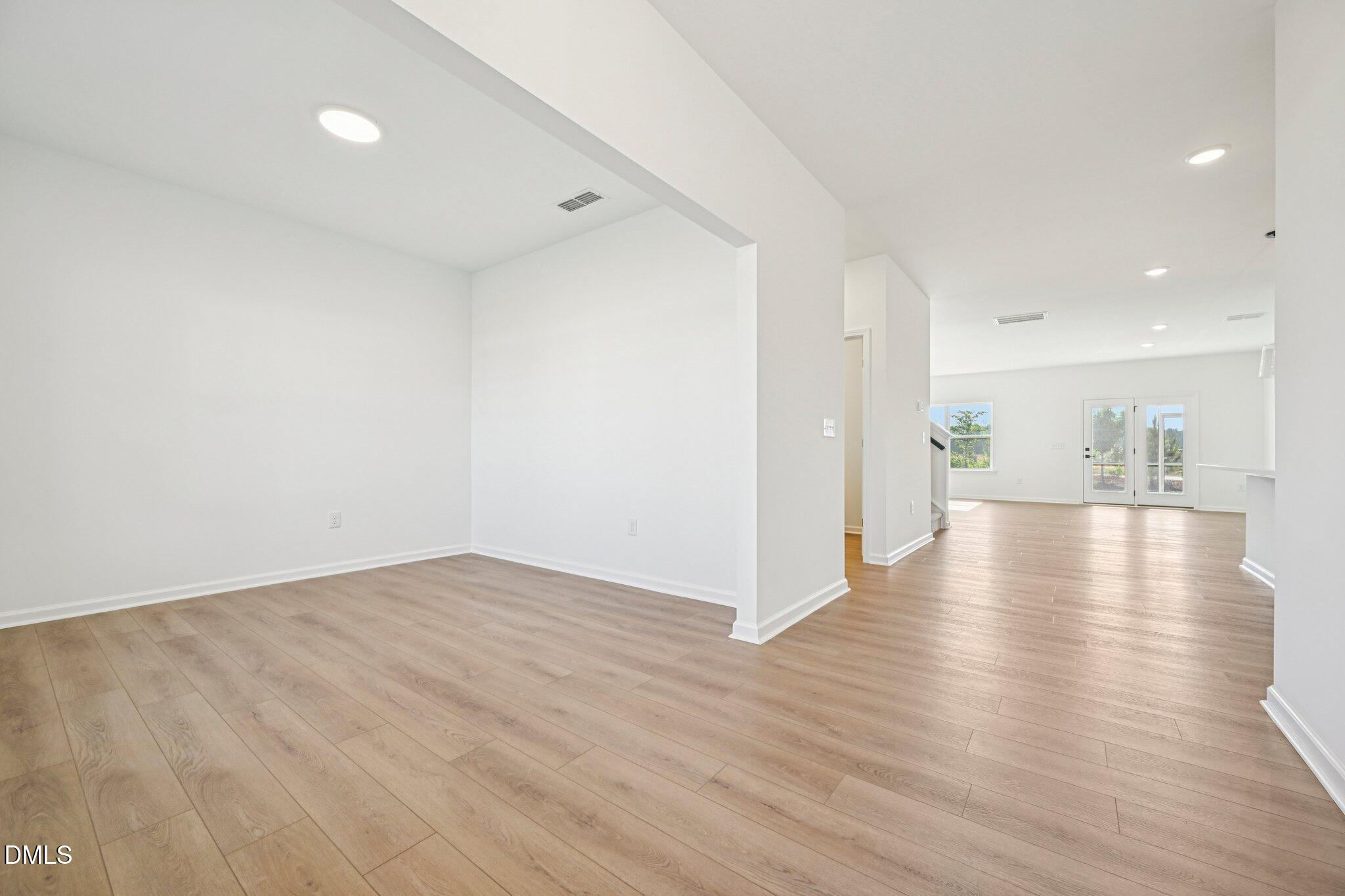 142 North Harvest Rdg Way, Unit HOMESITE 310 Clayton, NC 27520 - Photo 6 of 43 a view of an empty room with wooden floor and a kitchen