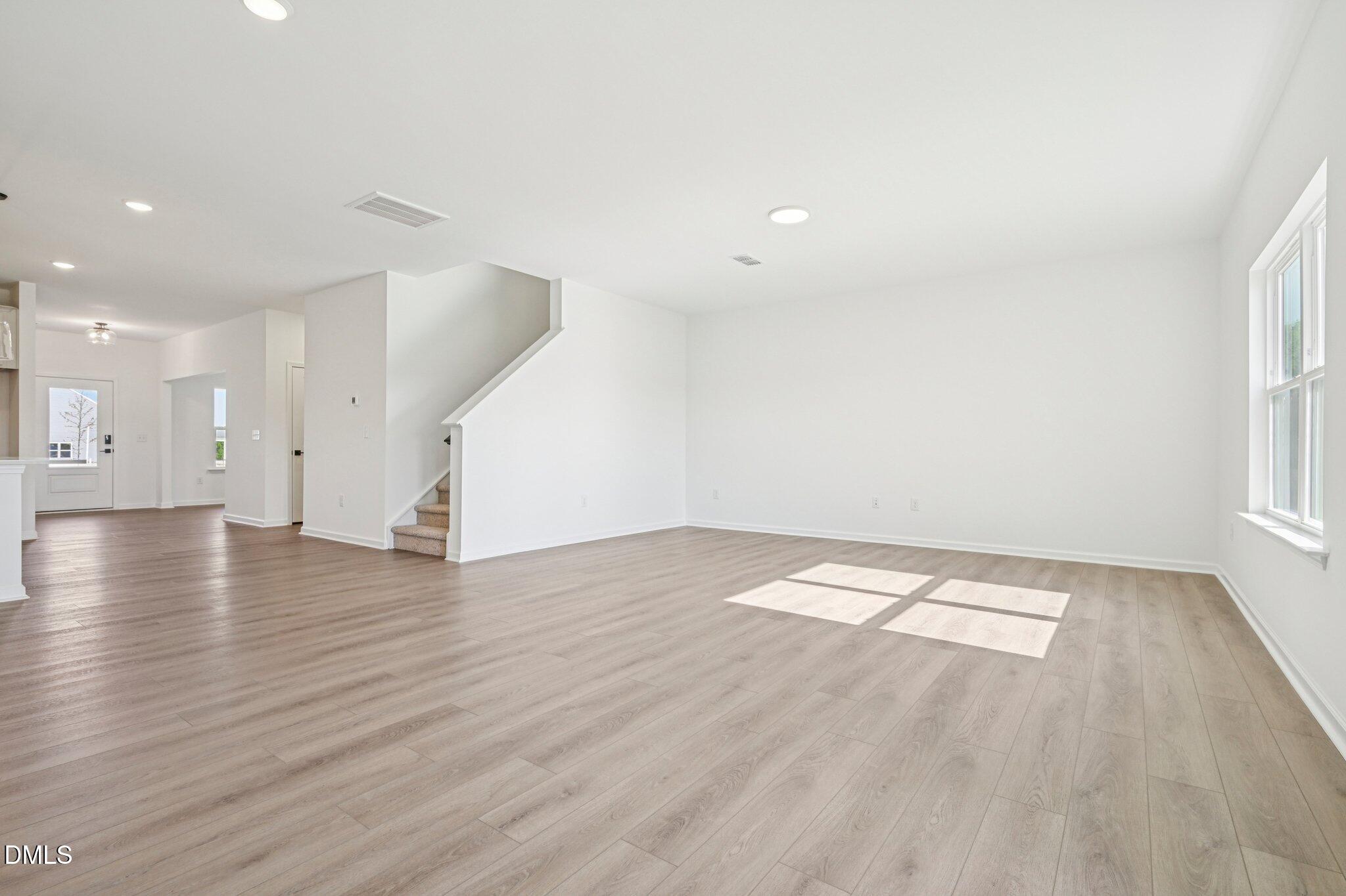 142 North Harvest Rdg Way, Unit HOMESITE 310 Clayton, NC 27520 - Photo 10 of 43 an empty room with wooden floor and windows