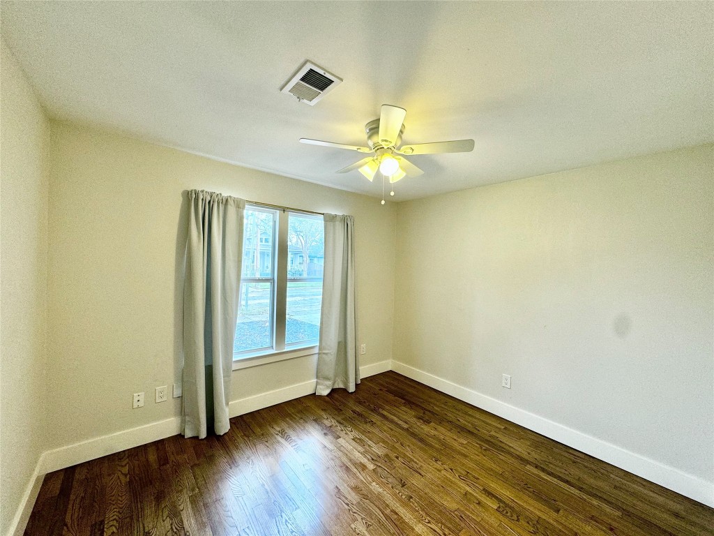 1035 Louise Street Houston, TX 77009 - Photo 14 of 28 a view of an empty room with wooden floor and a window