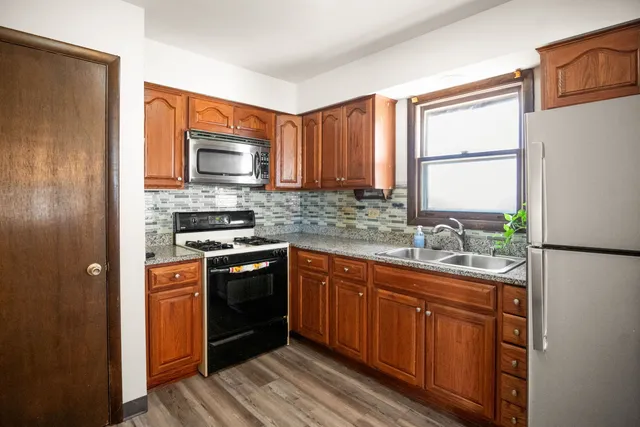 a kitchen with stainless steel appliances granite countertop a stove a sink dishwasher a refrigerator and a microwave oven