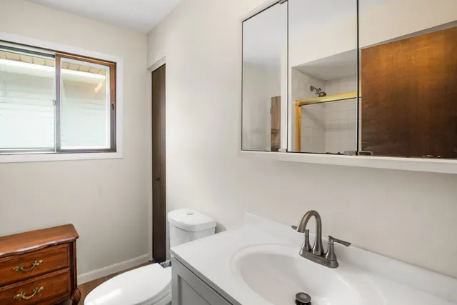 a bathroom with a toilet sink and mirror