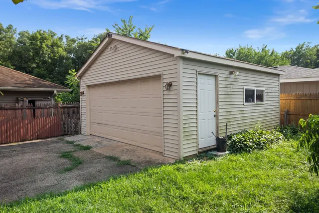 a view of backyard of house with wooden fence