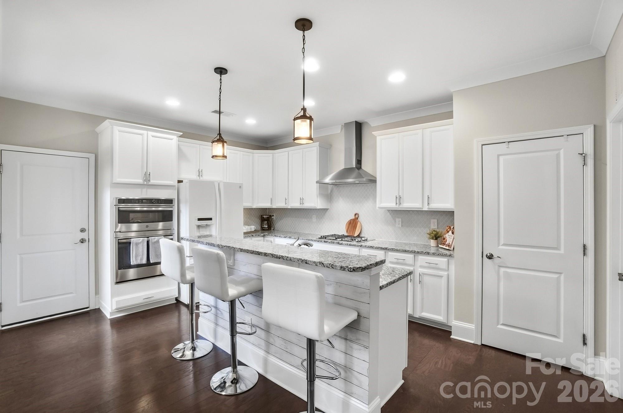 6270 Hove Road Mint Hill, NC 28227 - Photo 12 of 46 a kitchen with kitchen island granite countertop a sink cabinets and wooden floor